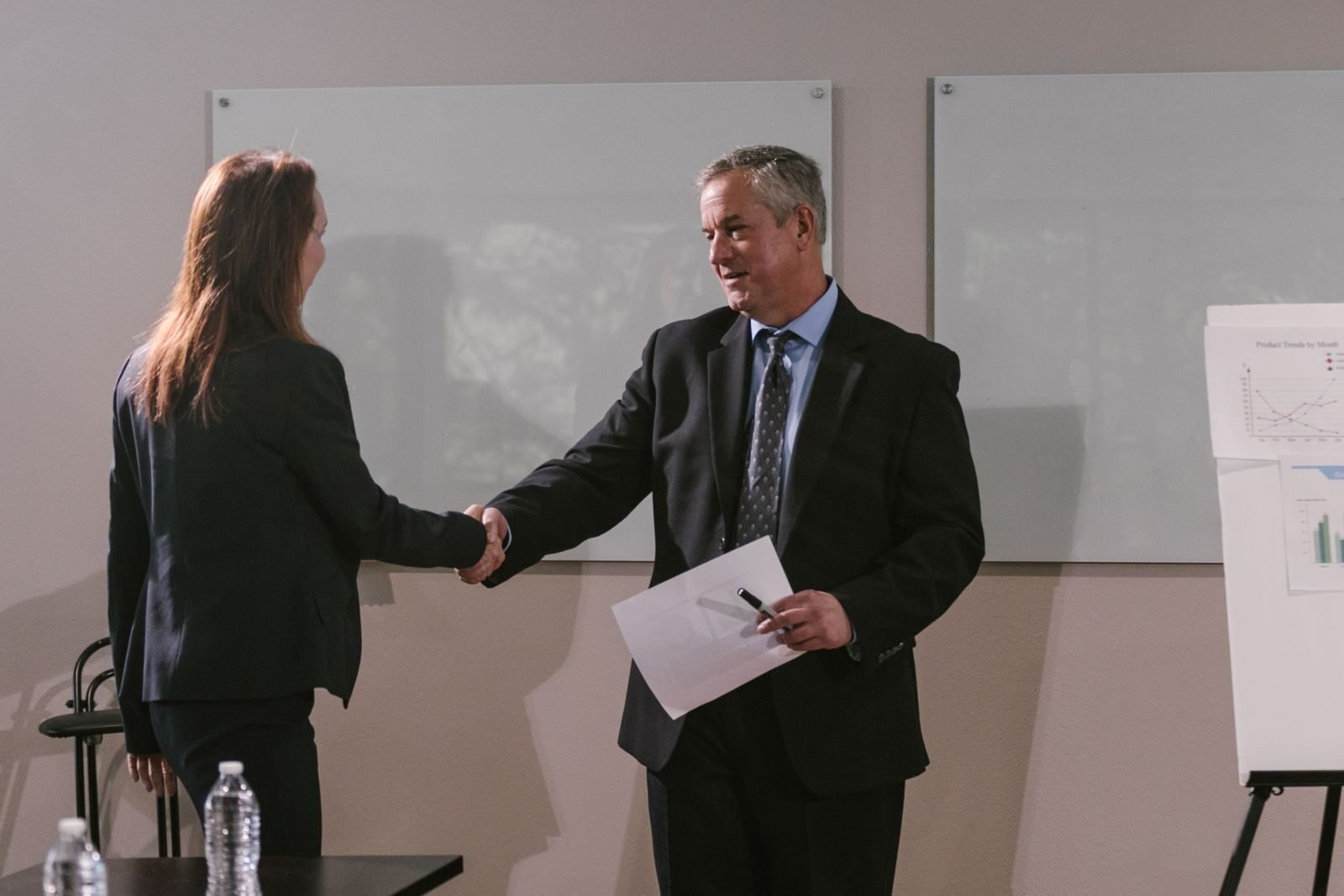 Photo by RDNE Stock project Two business professionals shaking hands in an office meeting room.
