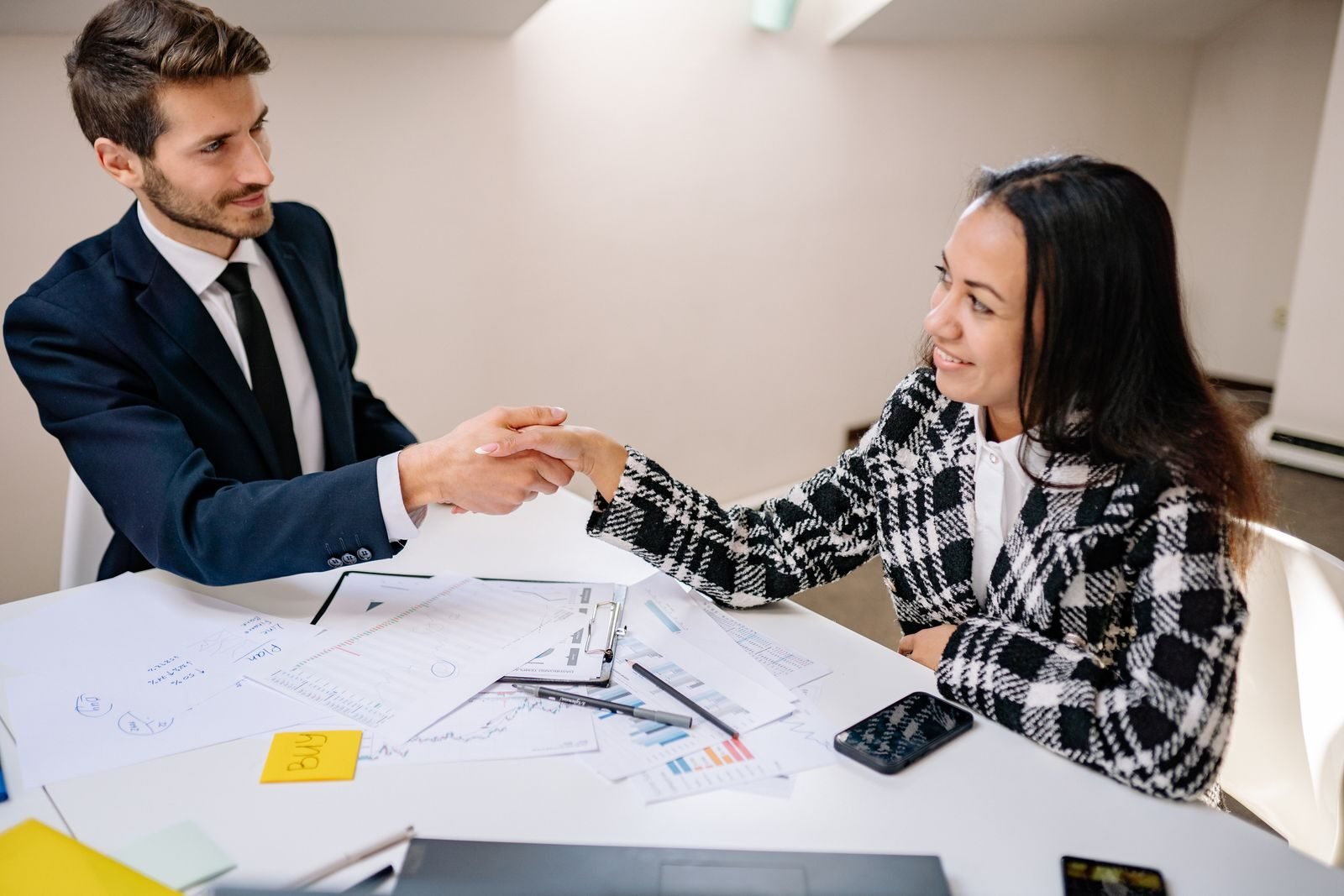 Photo by Yan Krukau Two business professionals shaking hands over a meeting table, symbolizing cooperation.